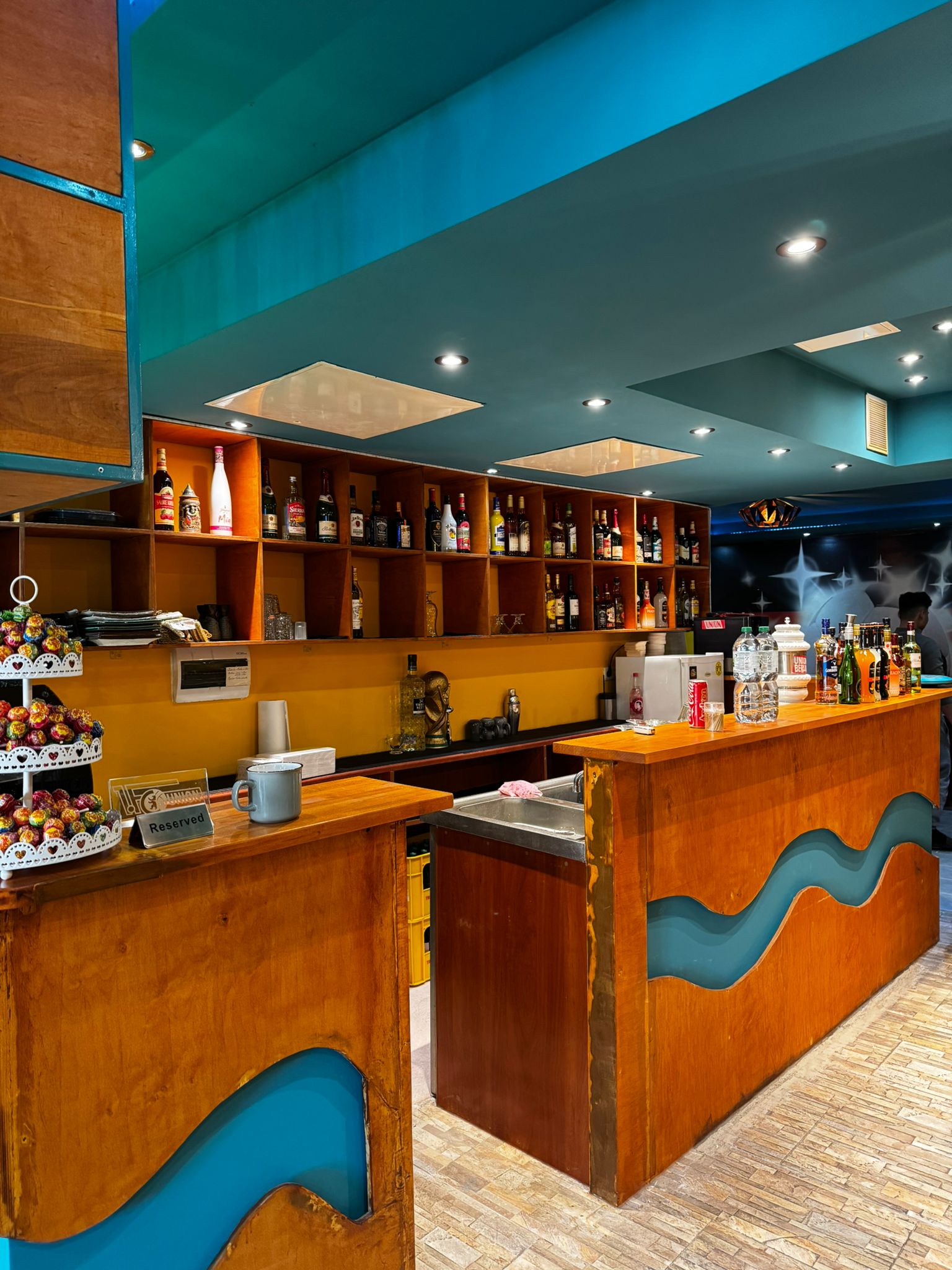 Innenansicht der Bar mit warmer Beleuchtung und umfangreicher Getränkeauswahl